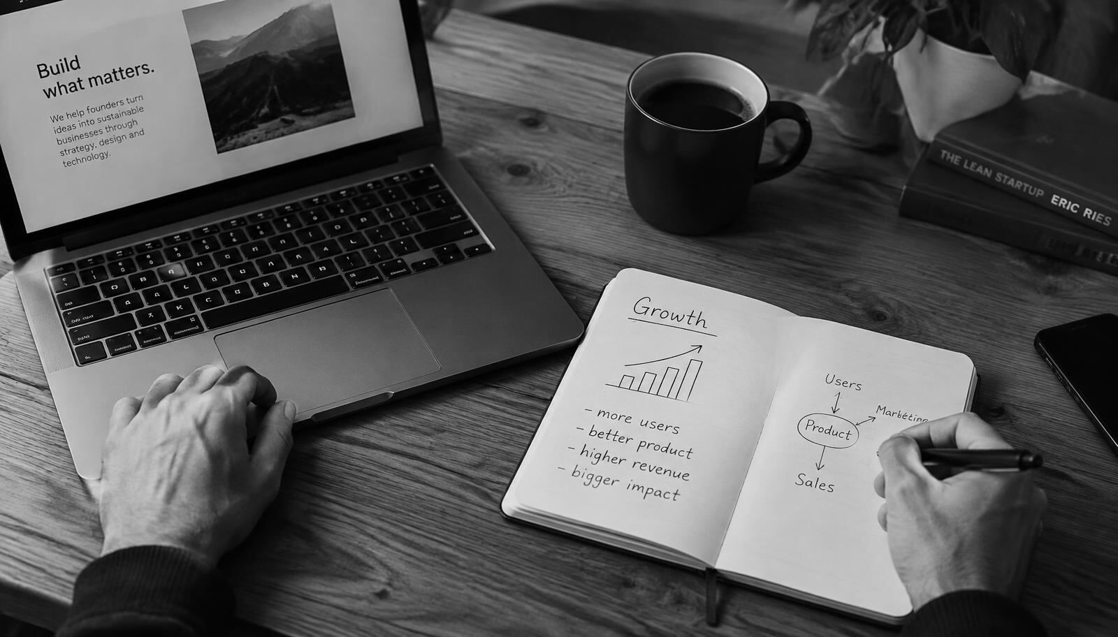 A founder sketching growth plans in a notebook beside a laptop